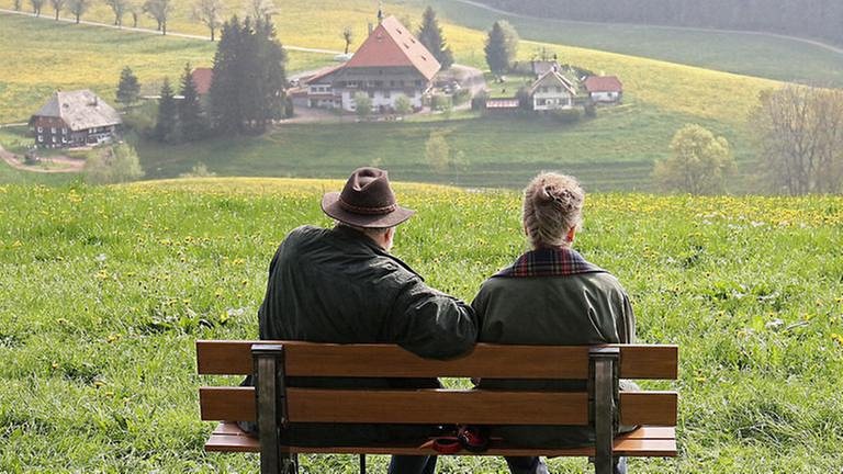 Hermann und Johanna sitzen auf einer Bank und blicken auf den Fallerhof (Foto: SWR, SWR/Johannes Krieg -)
