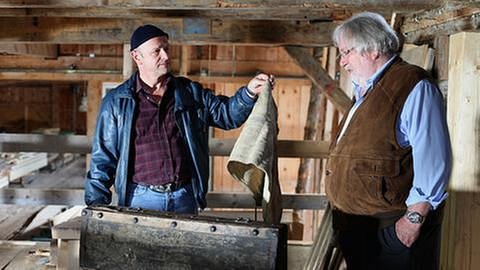 Toni hält Hermann in der Mühle einen alten Lappen hin (Foto: SWR, SWR/Rainer Bloch -)