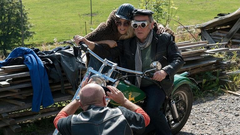 Toni fotografiert Ludwig und Sophie auf dem Motorrad, beide haben sich verkleidet (Foto: SWR, SWR/Stephanie Schweigert -)