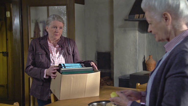 Evelyn steht mit einem Karton voller Ordner mit Johanna in der Küche (Foto: SWR)