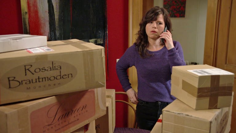 Eva steht inmitten von Kartons und telefoniert (Foto: SWR)