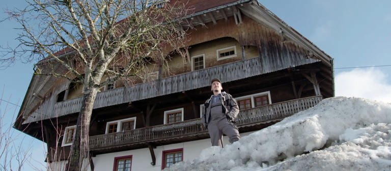 Sebastian steht vor dem Fallerhof im Schnee und sieht in die Ferne (Foto: SWR)