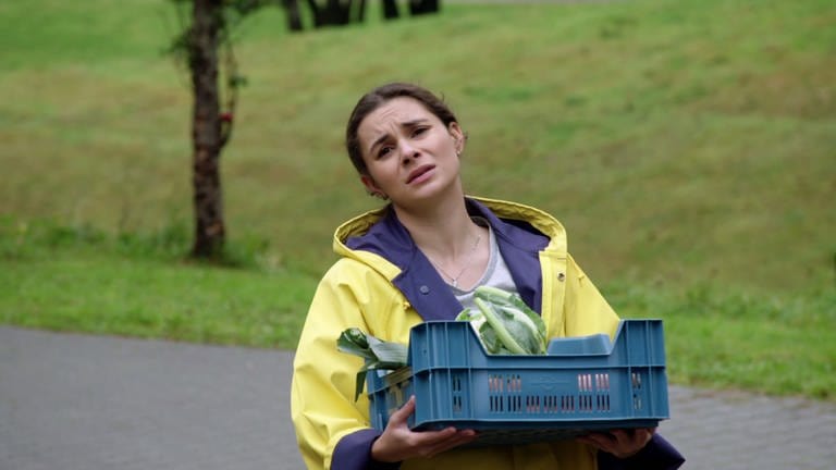 Jenny trägt einen Korb mit Gemüse und macht einen genervtes Gesicht (Foto: SWR)