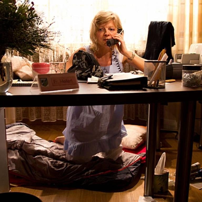 Frau Heilert kniet im Nachthemd vor ihrem Schreibtisch und telefoniert (Foto: SWR, SWR/Michael  Ciesielski -)