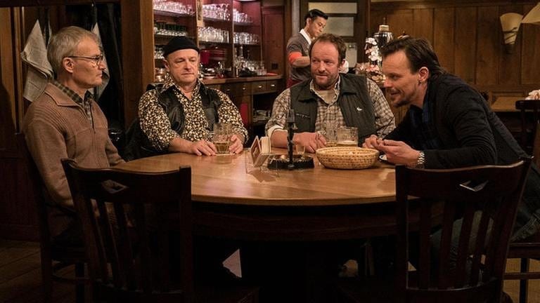 Karl, Toni, Bernd und Constantin am Stammtisch. Im Hintergrund sieht man Tu, wie er Bier zapft. (Foto: SWR, SWR/Stephanie Schweigert -)