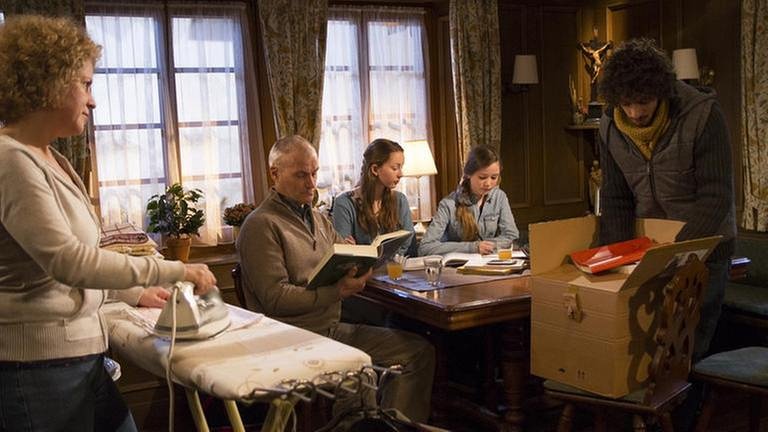 Karl sitzt mit Lena und Annika am Tisch, Bea bügelt und Albert packt Bücher aus einem Paket aus (Foto: SWR, SWR/Michael Ciesielski -)