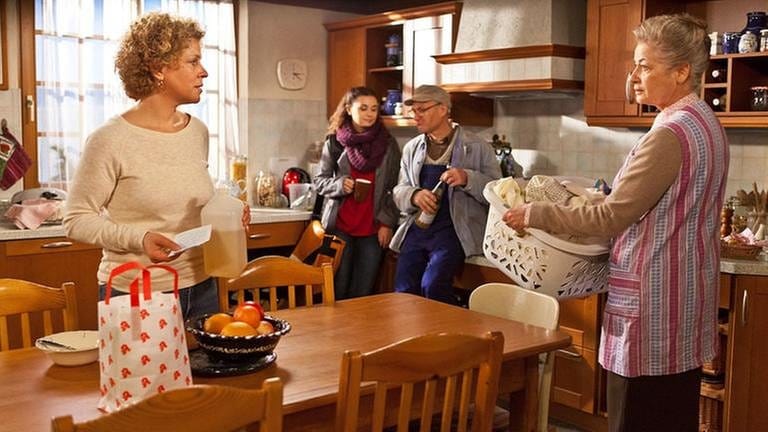 Johanna und Bea in der Küche, Johanna trägt einen Wäschekorb, im Hintergrund stehen Jenny und Karl (Foto: SWR, SWR/Peter Sebera -)