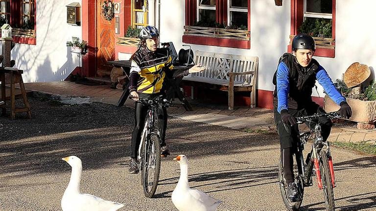 Albert und Sebastian verlassen auf ihren Fahrrädern den Fallerhof (Foto: SWR, SWR/Johannes Krieg -)