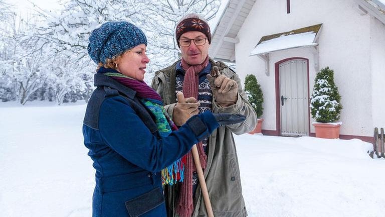 Bea und Karl stehen im Schnee vor der Hofkapelle und betrachten eine Patronenhülse (Foto: SWR, SWR/Peter Sebera -)