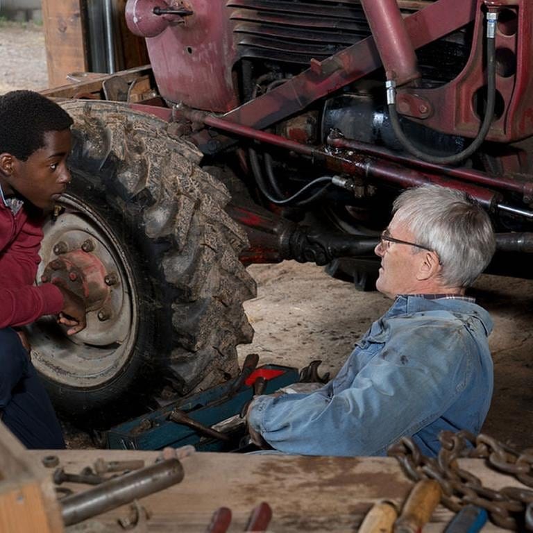 Tayo hilft Karl dabei, den Traktor zu reparieren