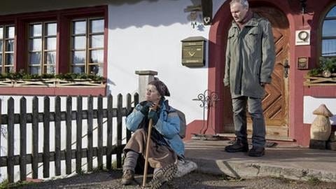 Lioba sitzt nachdenklich vor dem Fallerhof auf der Treppe, Karl steht hinter ihr (Foto: SWR, SWR/Stephanie Schweigert -)