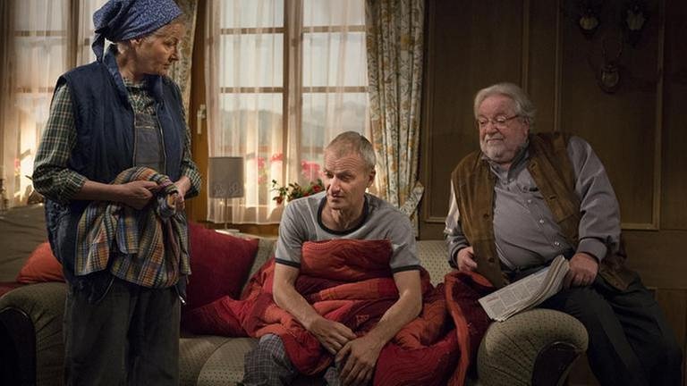 Johanna steht bei Karl und Hermann, die beide auf dem Sofa sitzen (Foto: SWR, SWR/Martin Furch -)