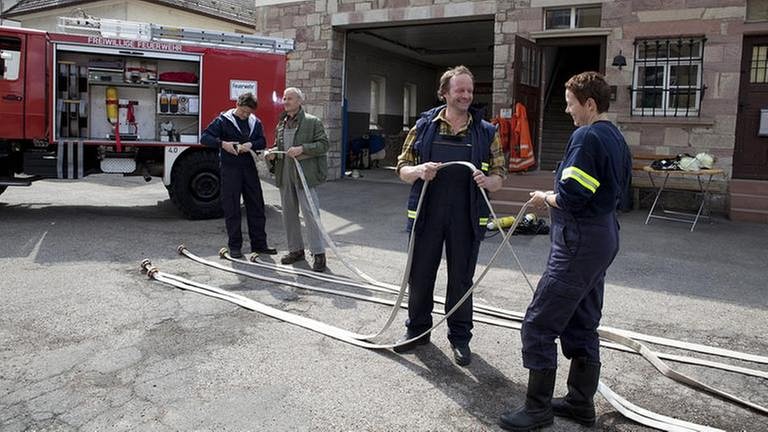 Bernd und Rosi reinigen ihr Arbeitsmaterial vor der Feuerwehrhalle (Foto: SWR, SWR/Peter Sebera -)