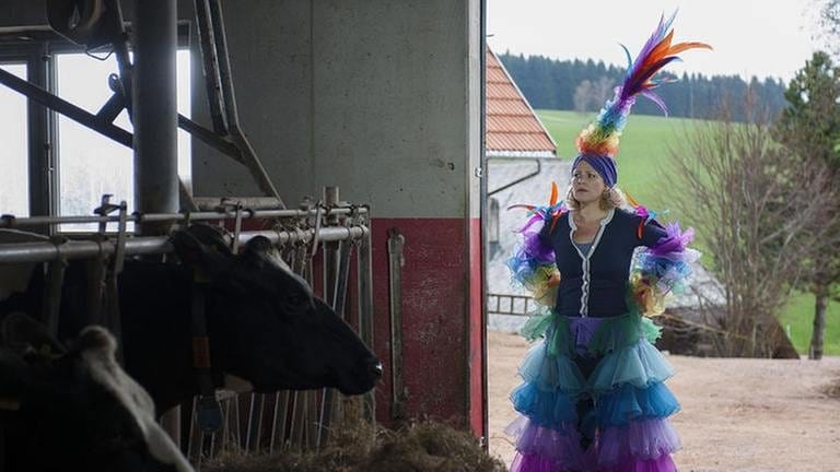 Bea steht im üppigen Faschingskostüm im Kuhstall (Foto: SWR, SWR/Stephanie Schweigert -)