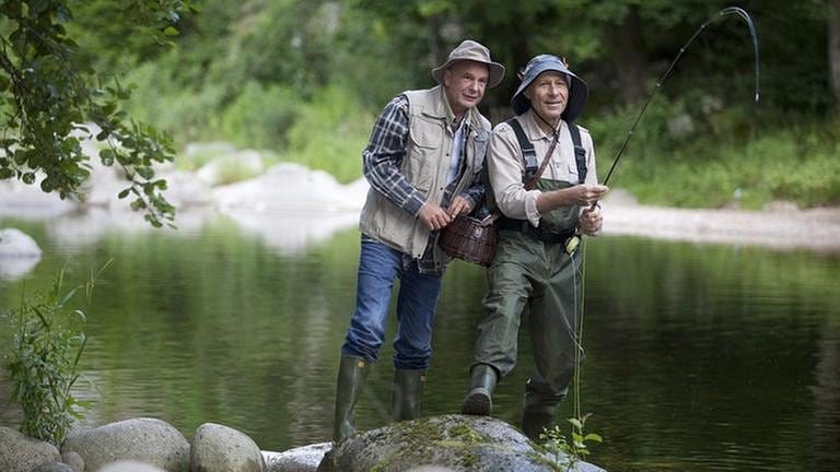 Franz und Heinz stehen auf einem großen Flusskiesel und angeln (Foto: SWR, SWR/Martin Furch -)