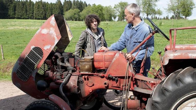 Albert und Karl stehen an einem roten Güldner-Traktor (Foto: SWR, SWR/Christina Fauth -)
