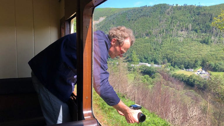 Der Kameramann lehnt sich aus einem anderen Fenster, um Ioan Lord bei seinen Erzählungen zu filmen.  (Foto: SWR, Kirsten Ruppel)