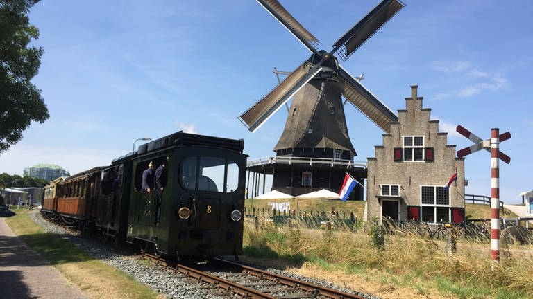 Das schönste Motiv auf der 20 km langen Museumsbahnstrecke Hoorn – Medemblik: die Kornmühle „De Herder“ auf dem Deich vor Medemblik. Samstags bewegt sie ihre Flügel und macht Mehl.