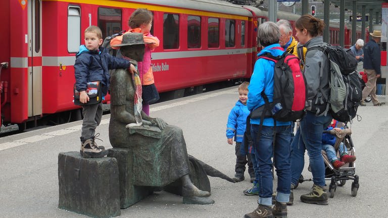 Die „Reisende“ des Bündner Künstlers Robert Indermaur umringt am Bahnsteig in Thusis (Foto: SWR, Alexander Schweitzer)