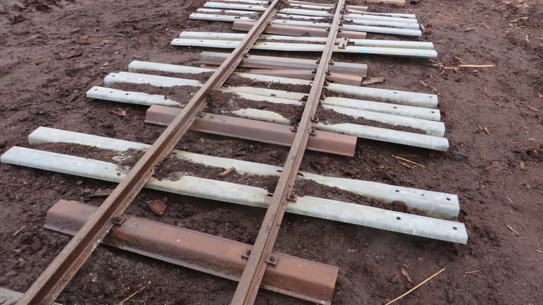 Neuerdings werden ausgediente Leitplanken vom Straßenbau als Eisenbahnschwelllen für die Moorbahnen verwendet. Sie sind größer und haltbarer als die alten Feldbahnschwellen (Foto: SWR, Bernhard Foos)