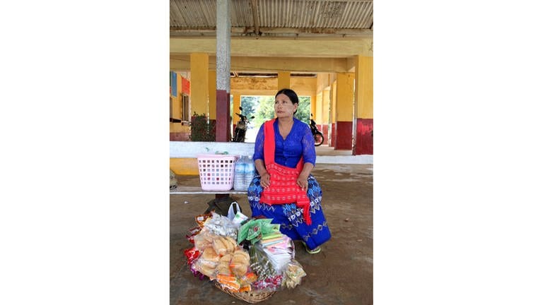 Gut ausgerüstet. Snackverkäuferin Daw Hla wartet mit ihrem Korb am Bahnhof. (Foto: SWR, Martin Schacht)