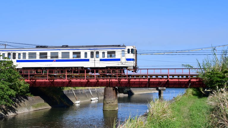 Unterwegs nach Ibusuki - ein Nahverkehrszug passiert eine der vielen kleinen Brücken. Typisch für Japan, die Brücke hat keinen seitlichen Weg und kein Geländer. (Foto: SWR, Harald Kirchner)