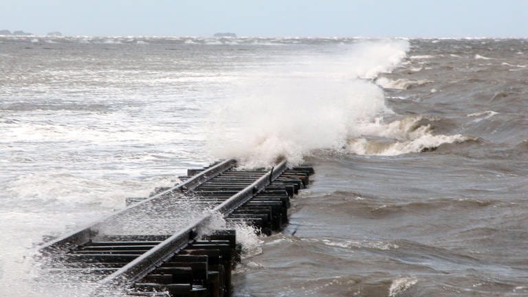 Wasser peitscht über die Schienen des Lorendamms. Bei diesem Sturm kann kein Mensch durchs Wattenmeer fahren. (Foto: SWR, Bernhard Foos)