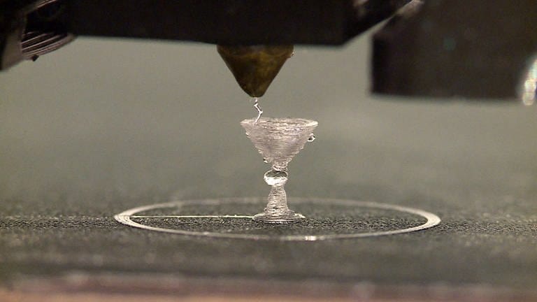 Der 3D-Drucker von Meike Schmidt „zaubert“ wieder ein Sektglas. Was so einfach aussieht ist das Ergebnis vieler Tests und von viel Geduld. (Foto: SWR, Andreas Stirl)