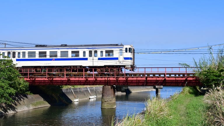 Unterwegs nach Ibusuki - ein Nahverkehrszug passiert eine der vielen kleinen Brücken. Typisch für Japan, die Brücke hat keinen seitlichen Weg und kein Geländer. (Foto: SWR, Harald Kirchner)