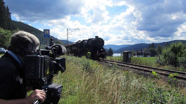 Kameramann Christoph Feller filmt den Dampfzug mit Blickrichtung Titisee und Feldberg. (Foto: SWR, SWR - Bernhard Foos)