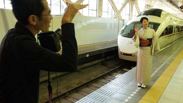 Photo-shooting vor dem Romancecar der Bahngesellschaft Odakyu Electric Railway im Tokyoter Bahnhof Shinjuku.