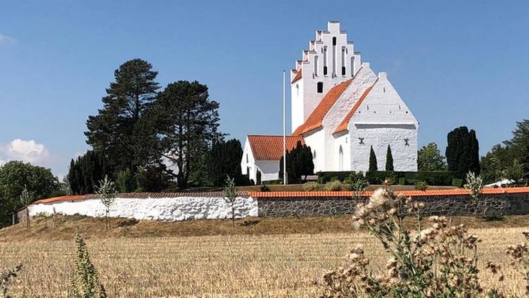 Idylle an der Bahnstrecke: auf Giebeldach-Kirchen in weiß oder rot trifft man häufig in Dänemark - hier eine in Rislev auf Seeland. (Foto: SWR, SWR - Kirsten Ruppel)