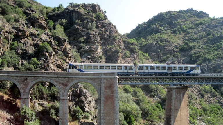Zug auf Gitter- und Bogenbrücke - Spektakuläre Streckenführung – die korsische Meterspurbahn fährt über 34 Viadukte.