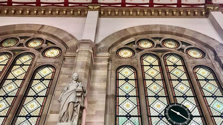 In der Haupthalle des Straßburger Hauptbahnhofes die allegorische Frauenfigur „Industrie“, die als Symbol für die Industrie eine Lok in der Hand hält.