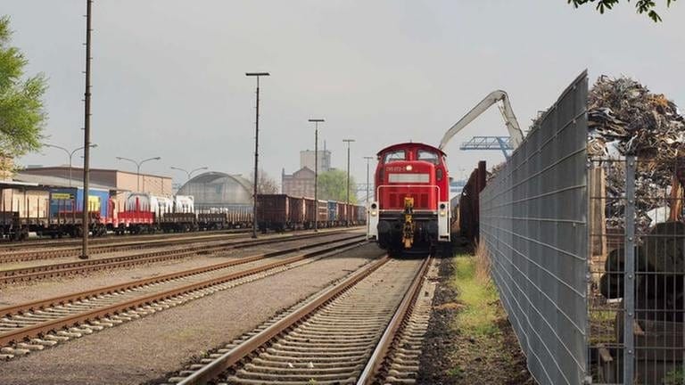 Ein Kran belädt einen Güterzug im Kehler Hafen mit Holzhackschnitzeln.