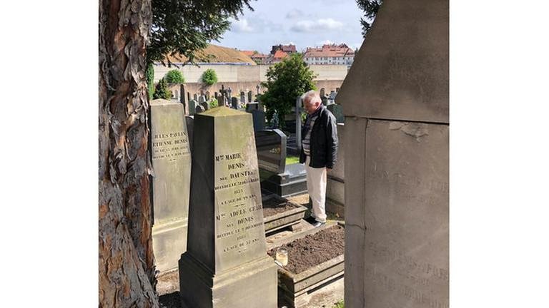 Werner Schreiner auf dem St.-Helenen-Friedhof in Strasbourg am Grab von Paul v. Denis, dem Erbauer der ersten deutschen Eisenbahn zwischen Nürnberg und Fürth – er war ein Franzose. (Foto: SWR, SWR - Alexander Schweitzer)