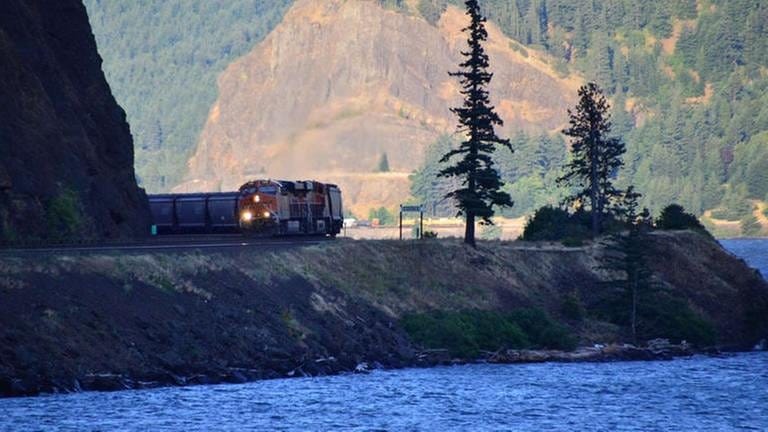 Ein Güterzug der BNSF kommt um die Ecke und wieder ist winzig am anderen Flussufer ein Zug der Union Pacific zu sehen. (Foto: SWR, SWR - Harald Kirchner)