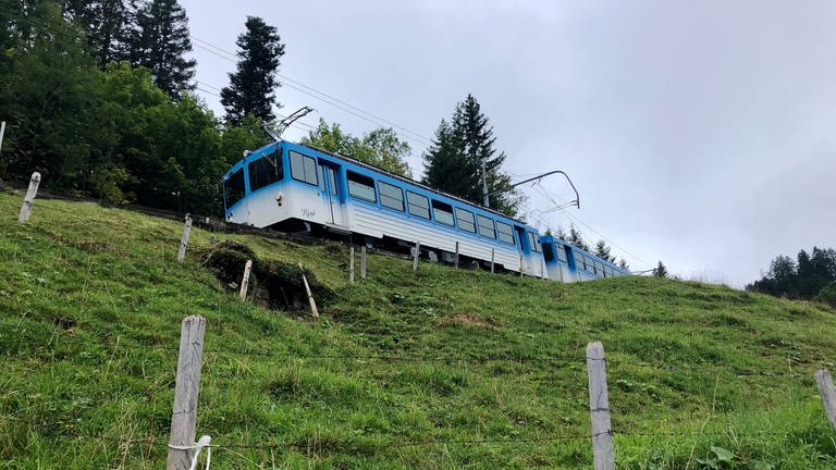 Auf der Nordseite geht es auf der Strecke der Arth-Rigi-Bahn mit einem blau-weißen Elektrotriebwagen aus den 1980er Jahren bergab. Von den Rigi-Bahnern wird er wegen seiner Farbpunkte liebevoll „Flöckli“ genannt. 