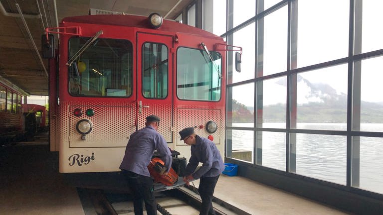 Ein „Beeri“ – so heißen die rot-weiß-gefleckten Triebwagen der Vitznau-Rigi-Bahn – wird mit einer Kupplung versehen.  (Foto: SWR, Kirsten Ruppel)