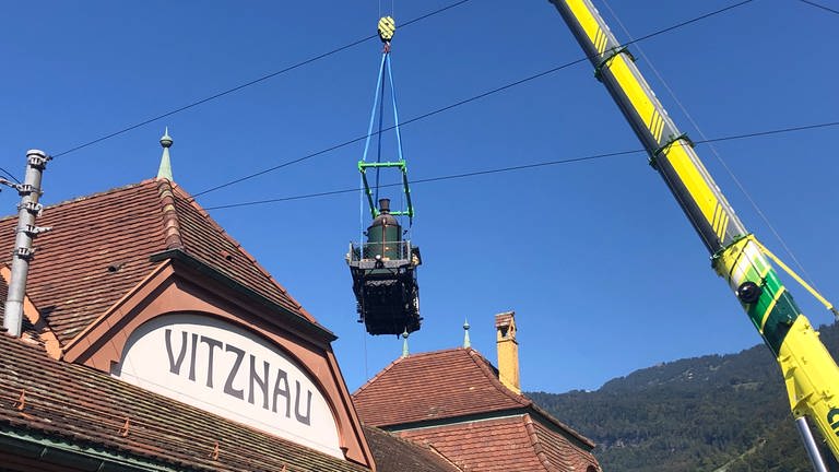 In Vitznau geht Lok 7 nochmal in die Luft: Sie muss über das Bahnhofsgebäude gehoben werden. (Foto: SWR, Kirsten Ruppel)