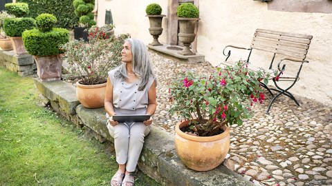 Frau im Garten mit Laptop (Foto: IMAGO,  imago images / Westend61)