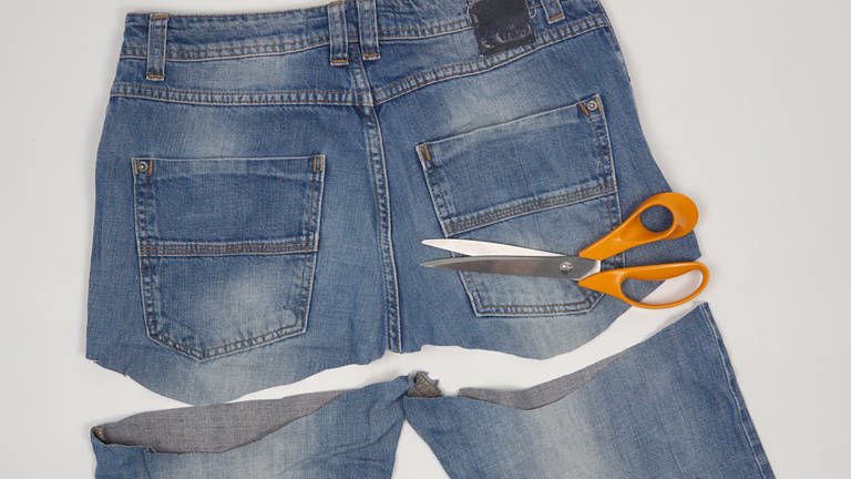 Die Hosenbeine möglichst weit oben und mit ca. 3 cm Abstand zu den Gesäßtaschen von der Jeans abschneiden.  (Foto: Laura Wilhelm)