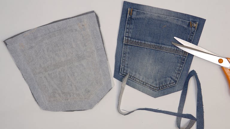 Auf die linke Stoffseite der Gesäßtaschen Klebevlies bügeln. Die Gesäßtaschen mit 1,5 cm Abstand zur Naht sauber ausschneiden.  (Foto: Laura Wilhelm)