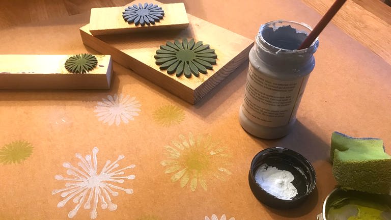 Den Bogen Lederpapier auf dem Tisch auslegen. Die Blüten der Stempel mit dem Schwämmchen mit Kreidefarbe betupfen. (Foto: Karolin Happel)