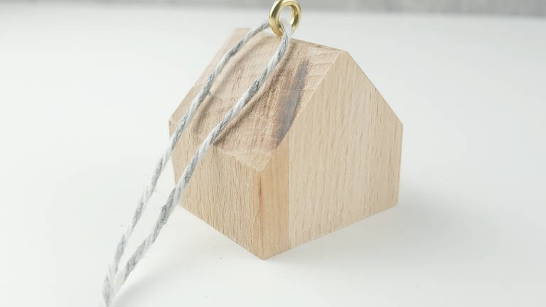 Noch ein Stück Schnur dran befestigen und schon kann das kleine Haus an den Baum oder an ein Geschenk gehängt werden. (Foto: Lisa Vöhringer)