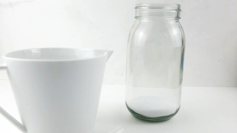 Nehmen Sie ein Glas und füllen Sie etwas Salz ein, so dass der Boden des Glases mit ca. 1 cm Salz bedeckt ist. (Foto: Lisa Vöhringer)