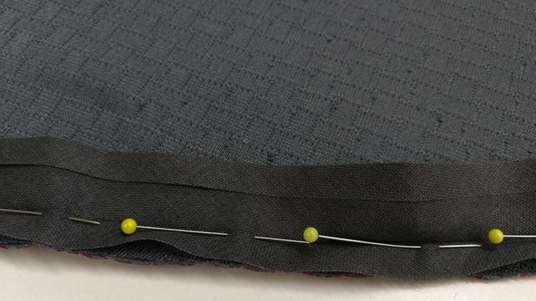 Variante 2 mit Baumwoll-Schrägband: Das vorgefalzte Baumwoll-Schrägband aufklappen und auf die linke Stoffseite aufstecken und nähen. (Foto: Privat - Manuela Besheimer Gräf)