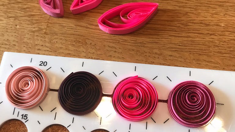 Für die Blüten Papierstreifen in eine runde Quilling-Schablone legen. (Foto: Karolin Happel)