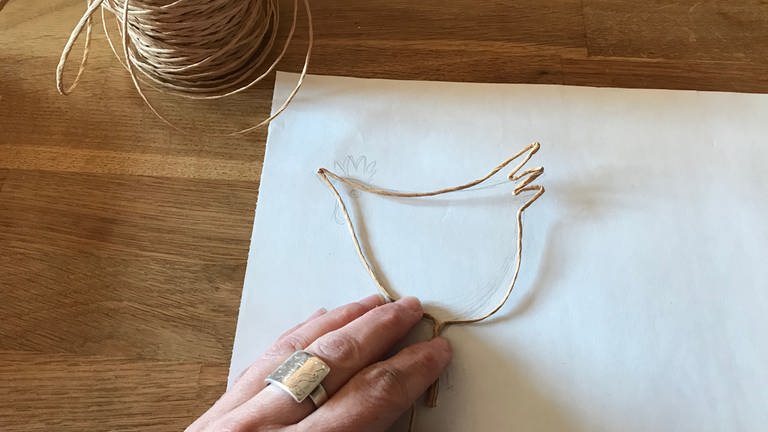 Mit dem Seitenschneider ein Stück Draht abschneiden und den Draht entlang der Zeichnung zu einem Huhn formen.  (Foto: Karolin Happel)