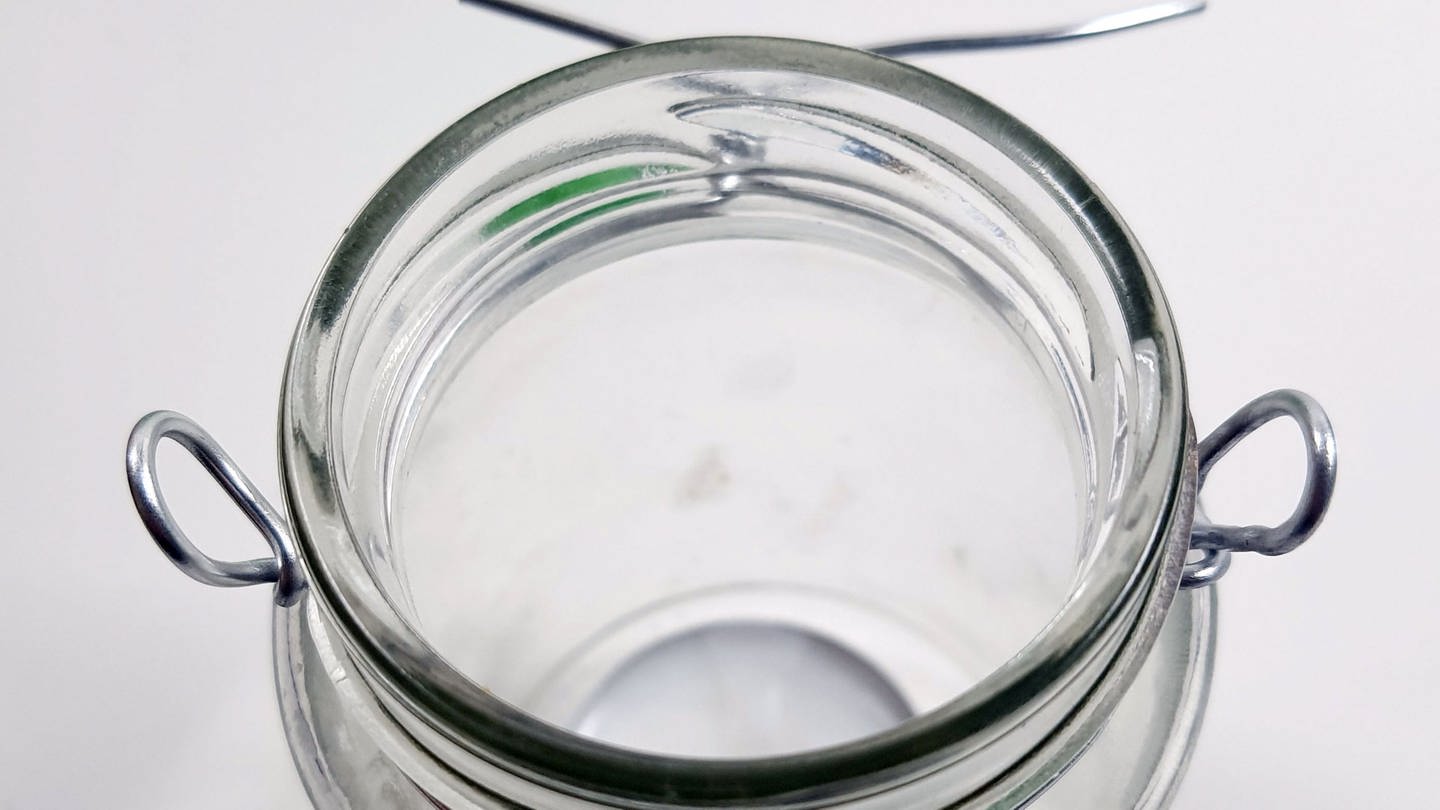 Etwas Draht abschneiden und diesen um den Rand des Marmeladenglases legen. Rechts und links vom Glas den Draht zu runden Ösen biegen und die Drahtenden anschließend fest verdrehen. (Foto: Lisa Vöhringer)